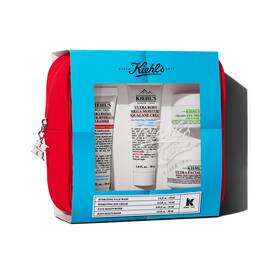 Kiehl's travel-sized skincare gift set in a red pouch, featuring multiple products visible through a blue-themed window.