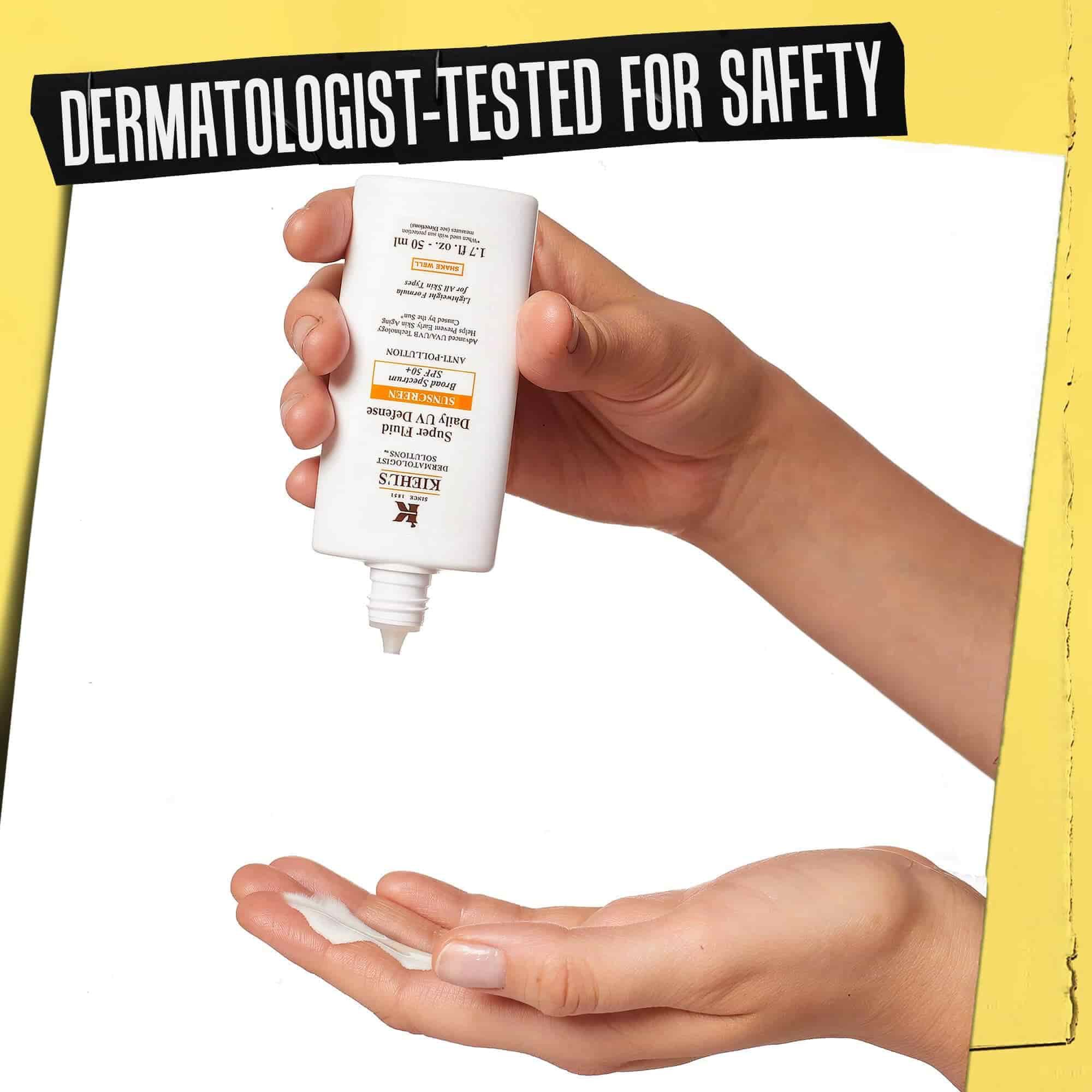Hand, auf die Ultra-Light Daily UV Defense gegeben wird, mit der Aufschrift „Dermatologisch auf Sicherheit getestet“.