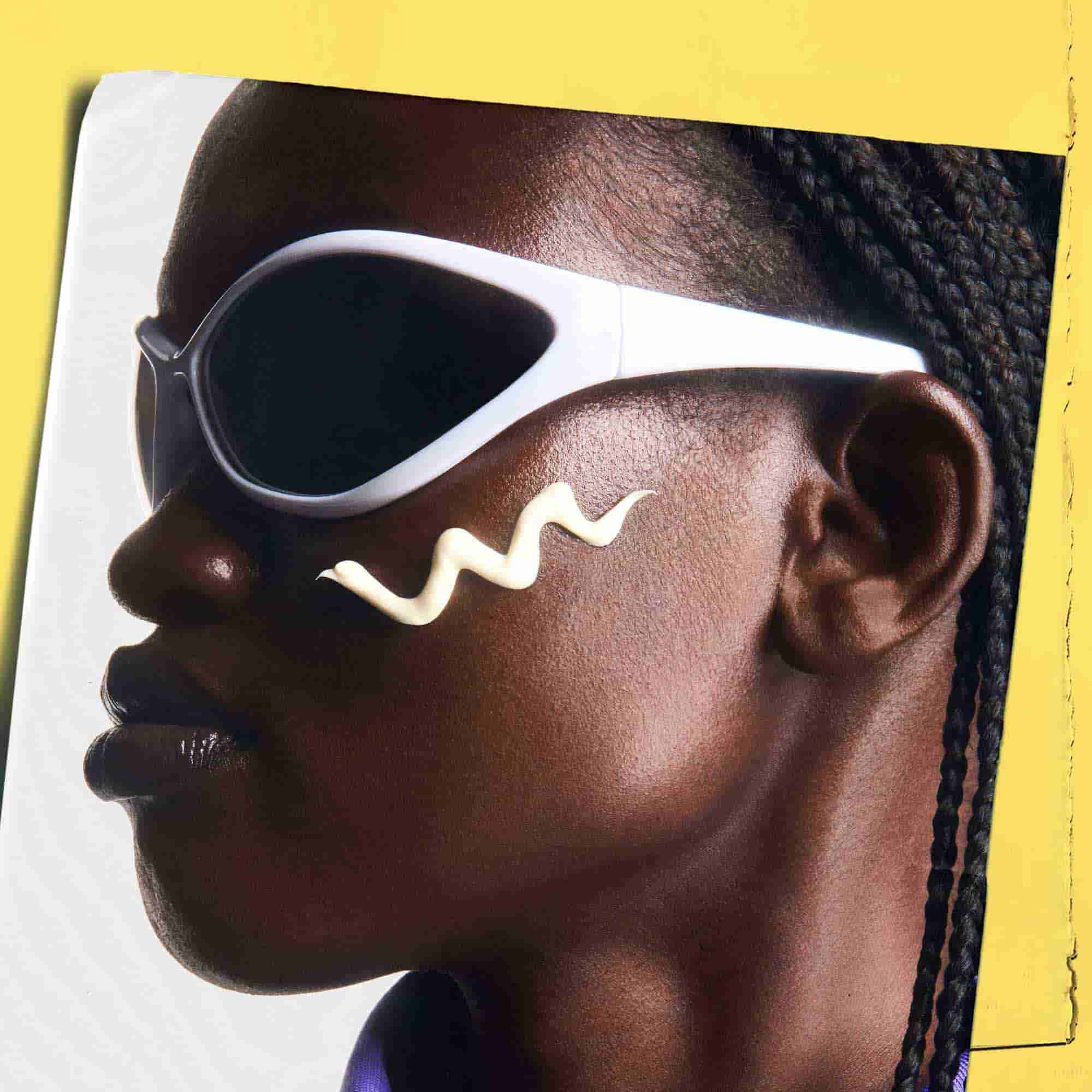 Ultra-Light Daily UV Defense auf die Haut aufgetragen, zeigt eine Person mit Sonnenbrille.