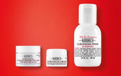 Kiehl's Mini-Produkt-Trio auf rotem Hintergrund: Ultra Facial Overnight Rehydrating Mask mit 10,5% Squalan, Ultra Facial Cream und Ultra Facial Toner fur alle Hauttypen