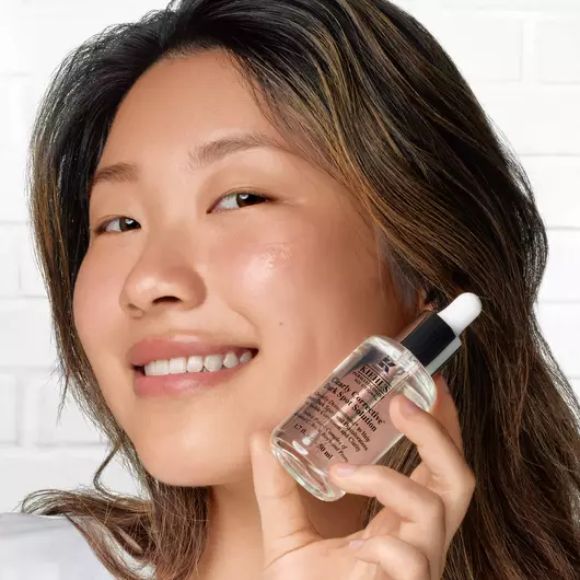 Frau zeigt die Clearly Corrective Dark Spot Solution von Kiehl's