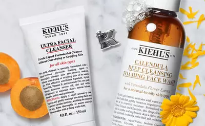 Kiehls Gesichtsreiniger: Ultra Facial Cleanser und Calendula Deep Cleansing Face Wash, umgeben von Bluten und Fruchten.