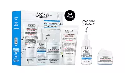 Bildbeschreibung: Ein Set von Kiehl's Produkten, das einen Ultra Facial Cleanser, ein Feuchtigkeitsserum und eine Gesichtscreme in Reisegroße zeigt, verpackt in einer blauen Box mit dem Hinweis "Full-Size Product".