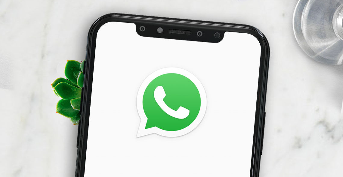Bild mit einem Smartphone mit Whatsapp Logo auf dem Bildschirm