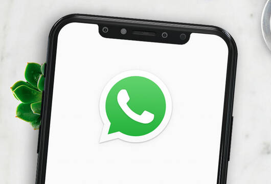 Bild mit einem Smartphone mit Whatsapp Logo auf dem Bildschirm