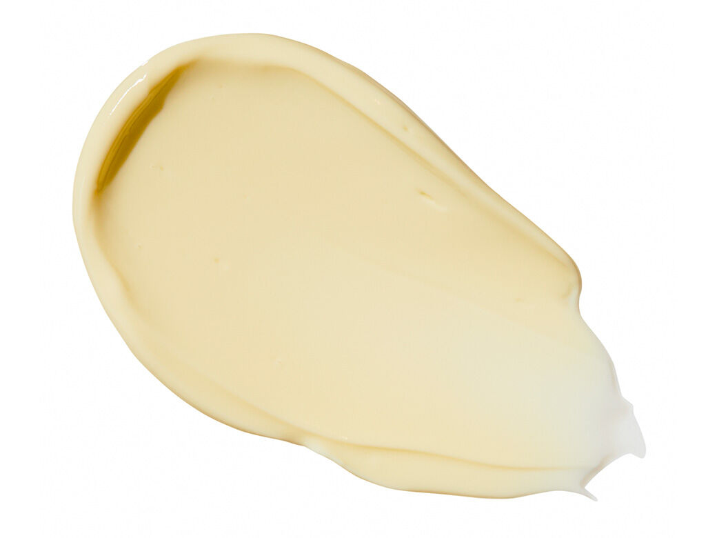 Ein cremefarbener bis hellgelber Klecks einer Creme oder Lotion mit glatter Textur, isoliert auf weißem Hintergrund.