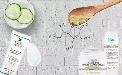 Hautpflegeprodukte von Kiehl's auf einem hellen Hintergrund, umgeben von Gurkenscheiben und einem Holzloffel mit grunem Pulver.