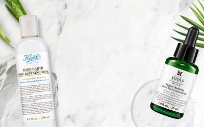 Zwei Kiehl's Hautpflegeprodukte: Rare Earth Pore Refining Tonic und Midnight Recovery Micro-Peel Konzentrat auf marmoriertem Hintergrund.