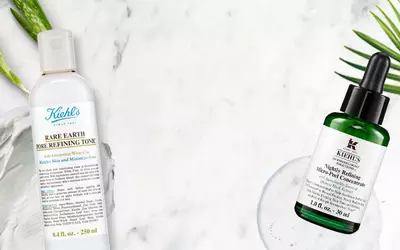 Zwei Kiehl's Hautpflegeprodukte: Rare Earth Pore Refining Tonic und Midnight Recovery Micro-Peel Konzentrat auf marmoriertem Hintergrund.