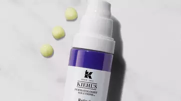 Flasche mit Kiehl's Retinol Skin-Renewing Serum, umgeben von zwei kleinen Tropfen.