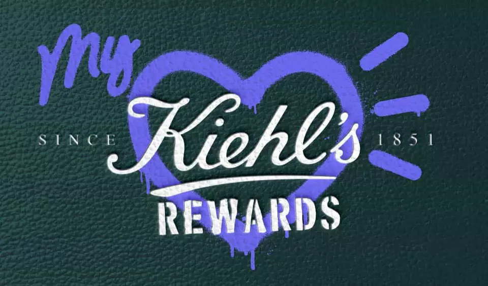 „My Kiehl’s Rewards“-Logo mit einem lila Herz auf einem grun strukturierten Hintergrund.