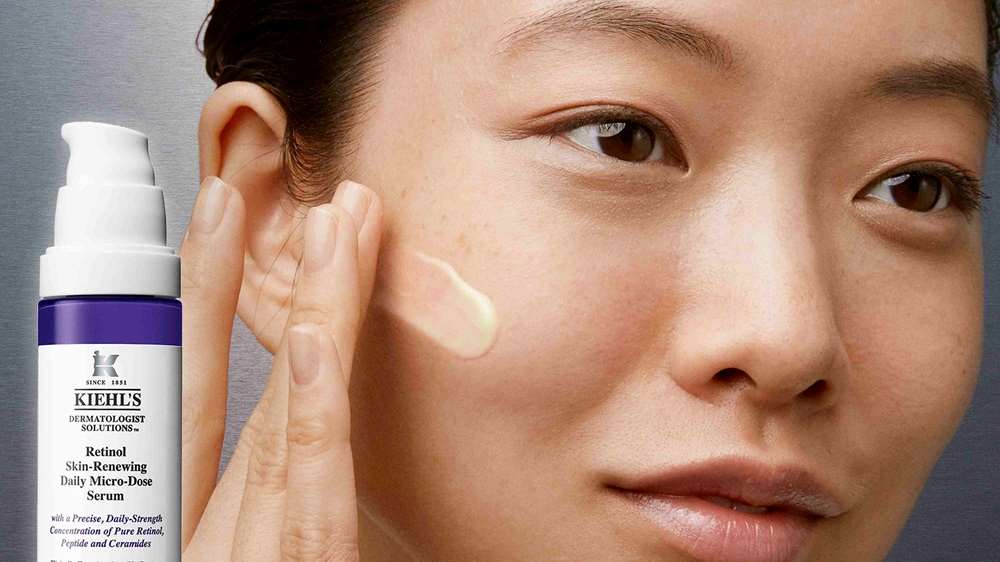 Gesicht einer Frau, die mit ihrer Hand etwas Retinol Serum auf die Wange gibt