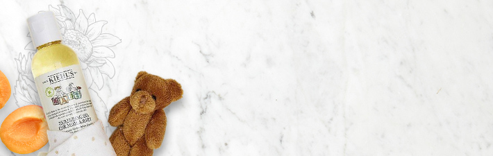 Banner der Kategorie Baby mit einem Kiehls-Produkt und einem Stoffbärem im Hintergrund